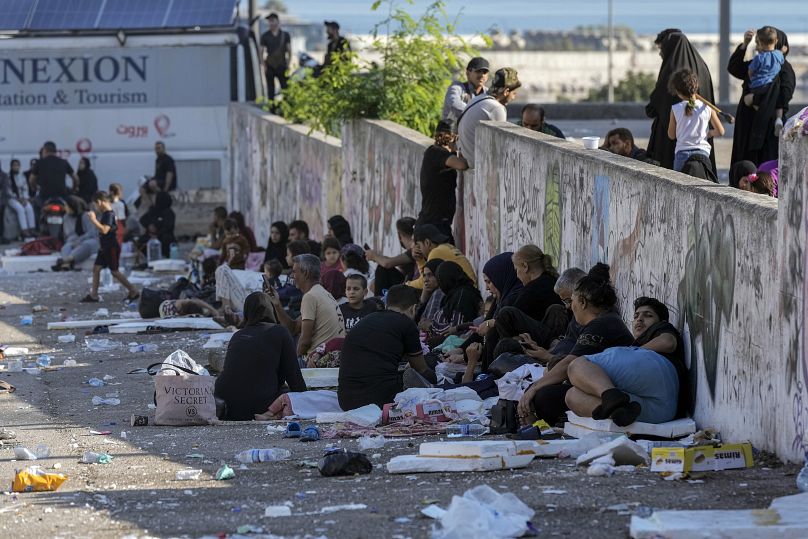 Families sit on the ground in central Beirut after fleeing Israeli in the southern suburbs, September 28, 2024