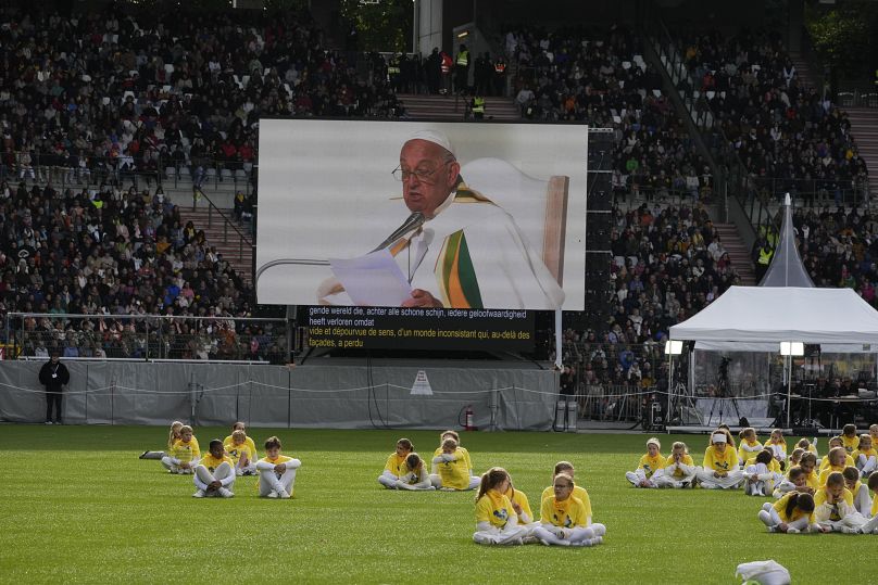 The faithful listen to Pope Francis' mass at King Baudouin Stadium in Brussels, September 29, 2024