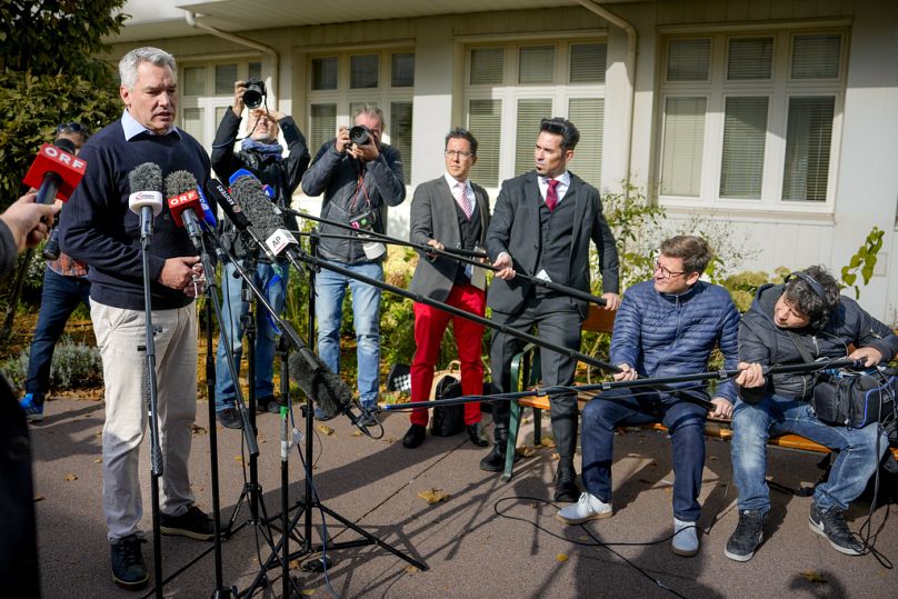 O chanceler austríaco Karl Nehammer fala aos meios de comunicação social à porta de uma assembleia de voto em Viena,