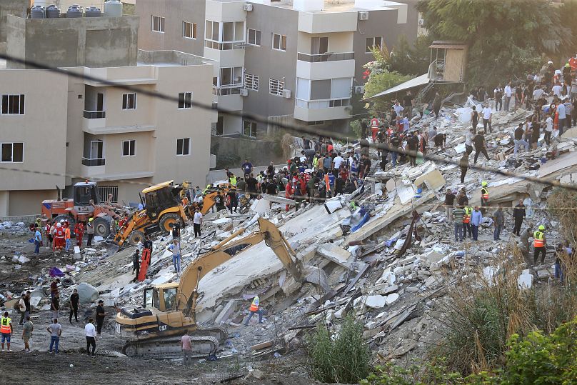 People and rescue teams search for victims after an Israeli airstrike on the southern port city of Sidon, September 29, 2024