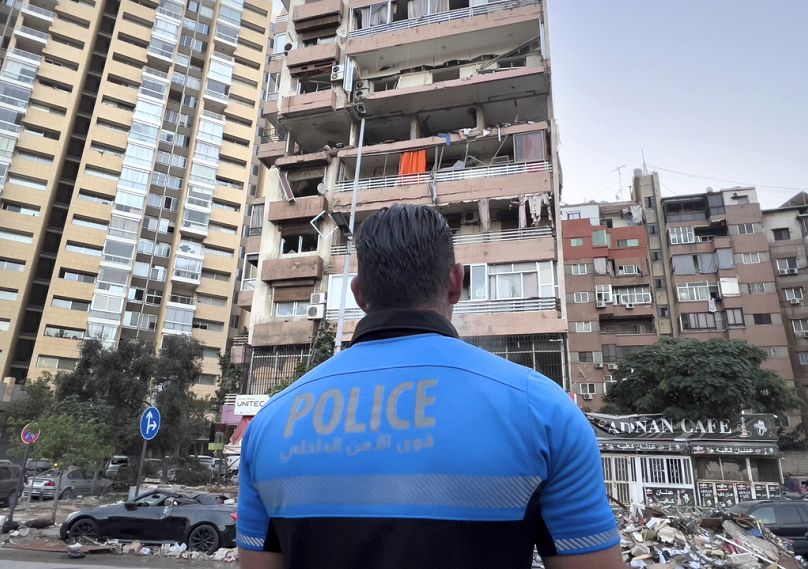 A Lebanese policeman looks at damaged apartments that were hit by Israeli strike early Monday, Sept. 30, 2024, in Beirut, Lebanon.