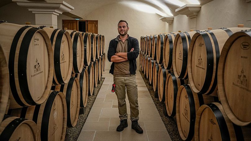 Arnaud Lavantureux, 35, is photographed between barrels of Chardonnay wine in the cellar of the property, in Chablis, Burgundy region, France, 25 September 2024. 