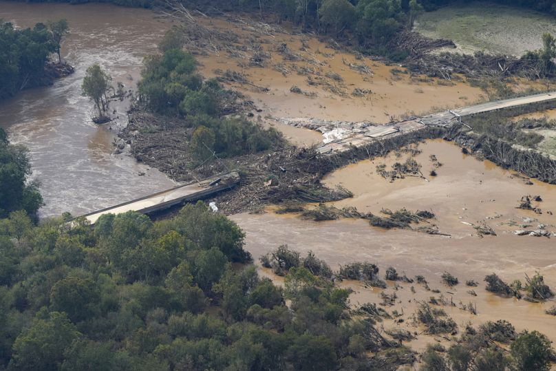 a damaged bridge and flooding in the aftermath of Hurricane Helene is seen along the Nolichucky River, Tennessee. 
