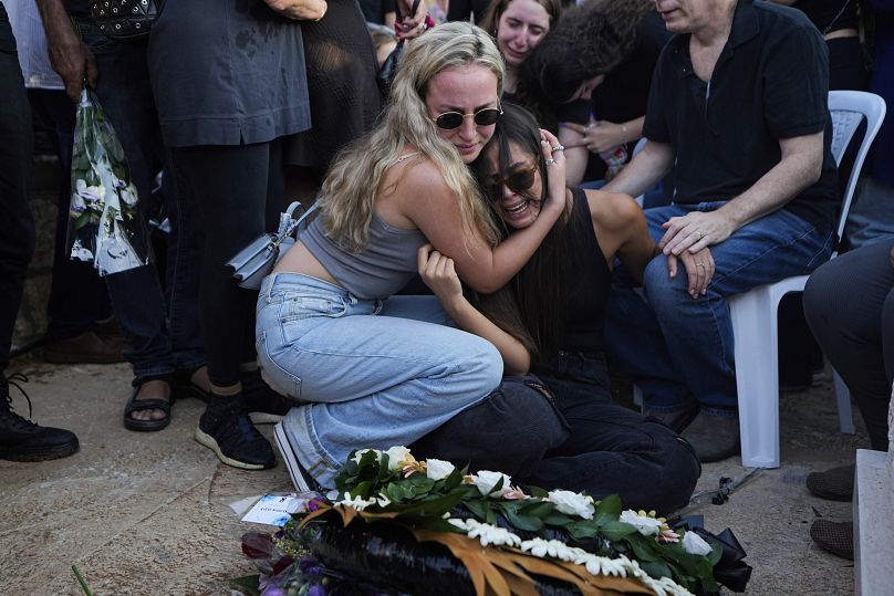 Israelíes lloran junto a la tumba de Maya Puder, de 25 años, durante su funeral en Zijrón Ya'akov, norte de Israel, 12 de octubre de 2023.