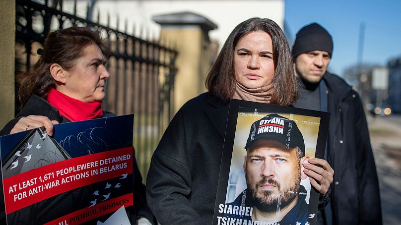 Belarusian opposition leader Sviatlana Tsikhanouskaya holds a portrait of her jailed husband, Siarhei Tsikhanouski, outside the Belarus Embassy, in Vilnius.