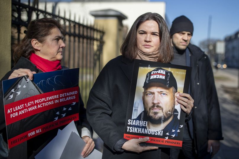 Sviatlana Tsikhanouskaya num protesto junto à embaixada bielorrussa em Vilnius, com um retrato do marido