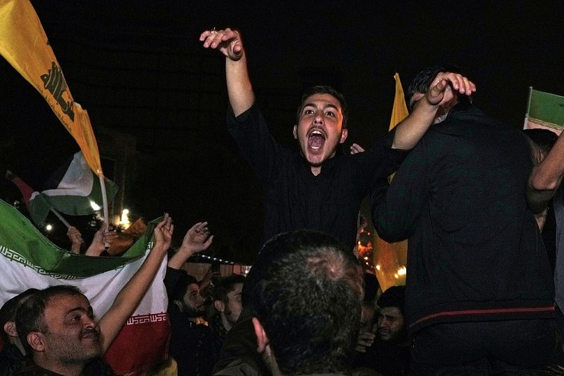 Demonstrators celebrate Iran's missile strike against Israel during a gathering in front of the British Embassy in Tehran, Iran, Tuesday, Oct. 1, 2024.