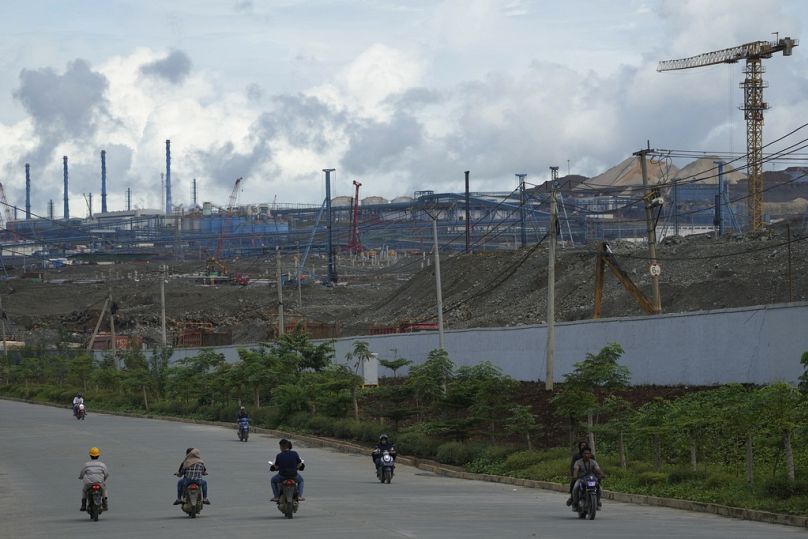 Motoristas pasan por el complejo industrial Weda Bay de Indonesia en Halmahera central, Molucas del Norte, junio de 2024