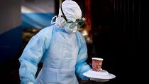 A medical worker carries a meal to a man in quarantine after coming into contact with a carrier of the Marburg virus in Kenya in 2014.