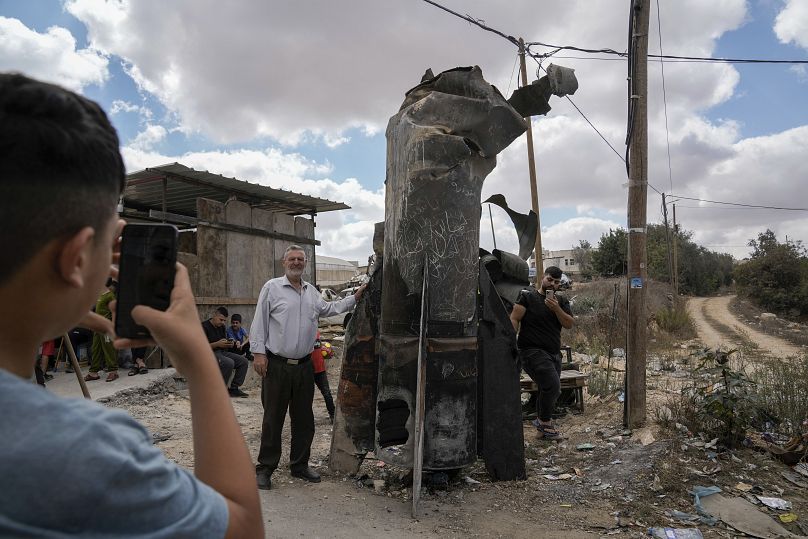 Palestinos se hacen fotos con los restos de un misil iraní interceptado por Israel, en la ciudad cisjordana de Hebrón, 2 de octubre de 2024.