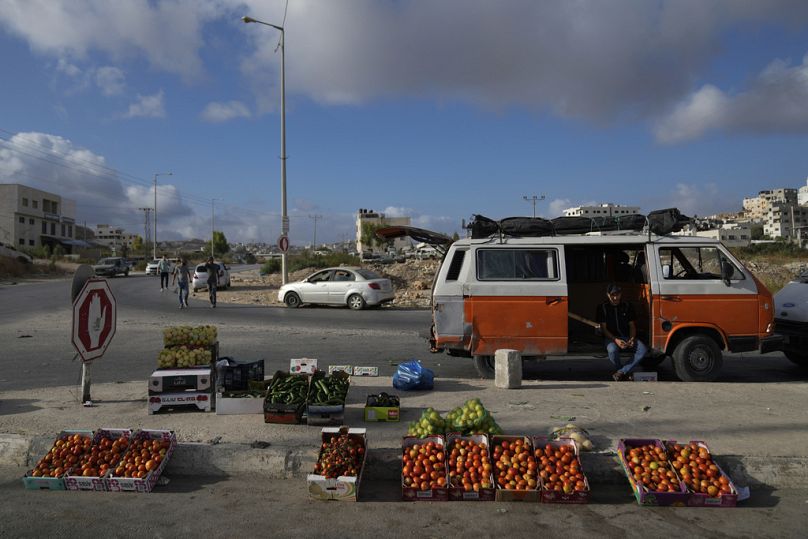 بائع متجول فلسطيني يعرض الخضروات للبيع في السوق الأسبوعي في الضواحي الشرقية لمدينة نابلس بالضفة الغربية، الاثنين، 16 سبتمبر، 2024. 