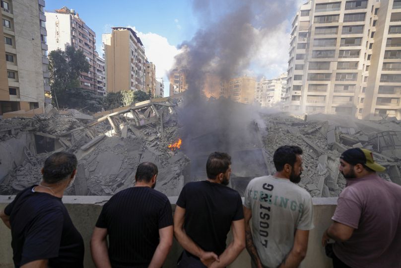 رجال يتفقدون الدمار الذي خلفته غارة إسرائيلية على الضاحية الجنوبية لبيروت