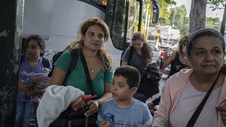 Greek citizens, who were evacuated from Lebanon with a Greek military transport aircraft stand outside the Greek Foreign ministry building in Athens, October 3, 2024