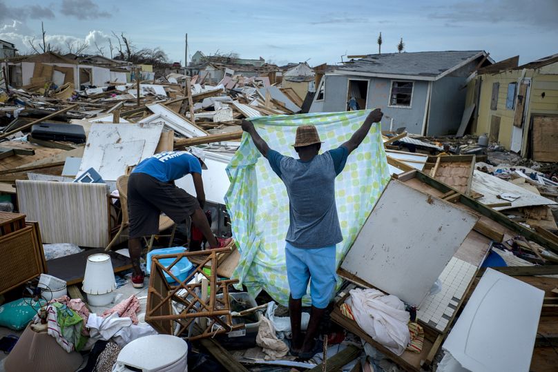 People  recover their belongings from the rubble in their destroyed homes, in the aftermath of Hurricane Dorian in Abaco, Bahamas in 2019. 