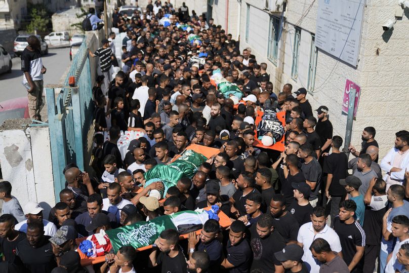 مشيعون يحملون جثامين 18 فلسطينياً قُتلوا في غارة جوية إسرائيلية 