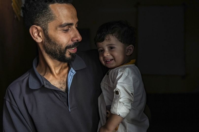مصطفى الطويل يحمل طفله علي، الذي ولد في 7 أكتوبر، في منزل عائلته في النصيرات، قطاع غزة، السبت، 5 أكتوبر، 2024.