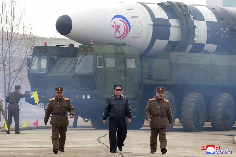 Kim Jong Un, Kuzey Kore'de açıklanmayan bir konumda Hwasong-17 kıtalararası balistik füzesi (ICBM) olduğu belirtilen füzenin önünde yürüyor, 24 Mart 2022.