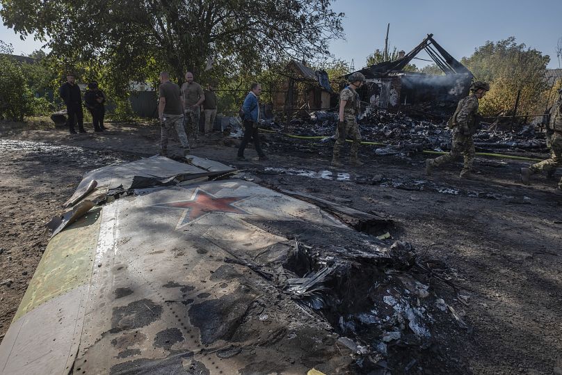 Ukrainian servicemen examine fragments of a Russian military plane that was shot down on the outskirts of Kostyantynivka, October 5, 2024