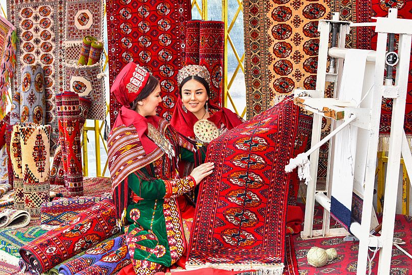 Two women weaving carpets