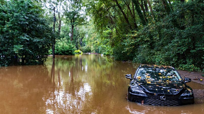 A partially submerged vehicle sits in floodwater from after Hurricane Helene passed the area, Sept 27, 2024, in Atlanta. 