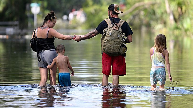 Dustin Holmes, Hailey Morgan and her children return to their flooded home in the aftermath of Hurricane Helene, 27 September 2024, in Crystal River, Fla. 