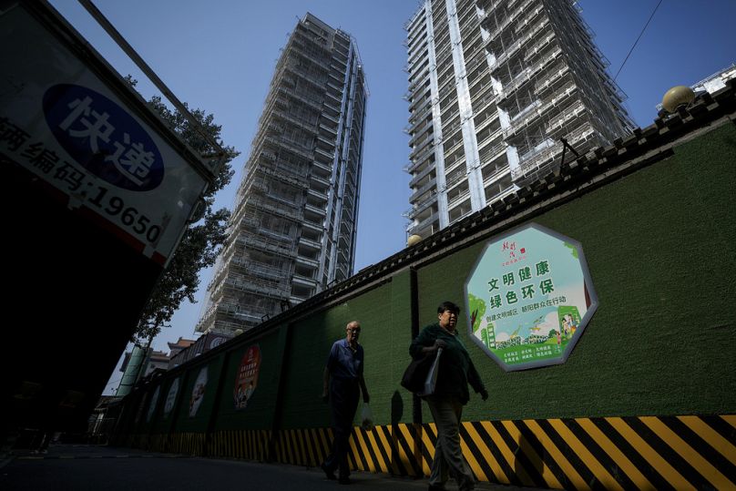 سكان يتجولون أمام موقع بناء مساكن فاخرة في بكين