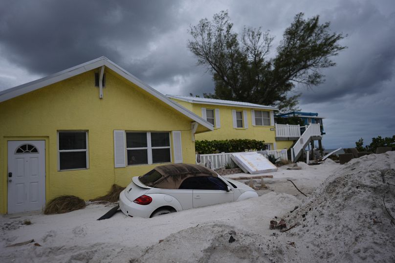 Une voiture est à moitié enterrée dans le sable sur la plage de Bradenton (Floride) juste après le passage de l'ouragan Hélène