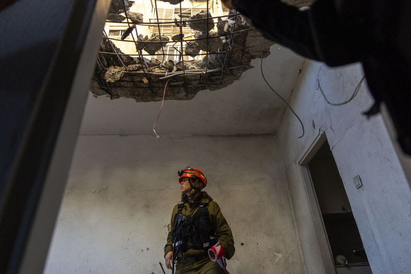 Un ufficiale dell'unità militare di comando esamina l'appartamento danneggiato dopo essere stato colpito da un razzo sparato dal Libano a Kiryat Yam, Israele, 8 ottobre 2024