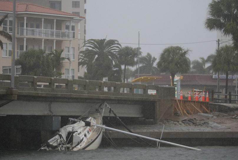 A boat damaged in Hurricane Helene rests against a bridge ahead of the arrival of Hurricane Milton, in South Pasadena, Fla., Wednesday, Oct. 9, 2024.