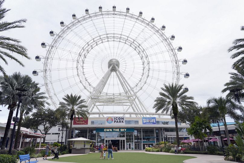 Florida'yı tehdit eden Milton Kasırgası nedeniyle kapatılan Orlando Eye dönme dolabının yanından geçen turistler, Icon Park'ta yürüyor