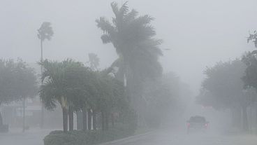 A Lee County Sheriff's officer patrols the streets of Cape Coral, Fla., as heavy rain falls ahead of Hurricane Milton