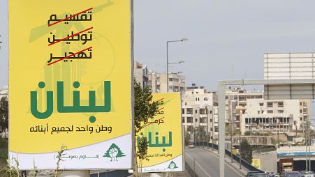 لافتات انتخابية لحزب الله مكتوب عليها باللغة العربية: ”تقسيم، توطين، تهجير (مشطوبة بالأحمر)، لبنان، 8 أبريل/نيسان 2009