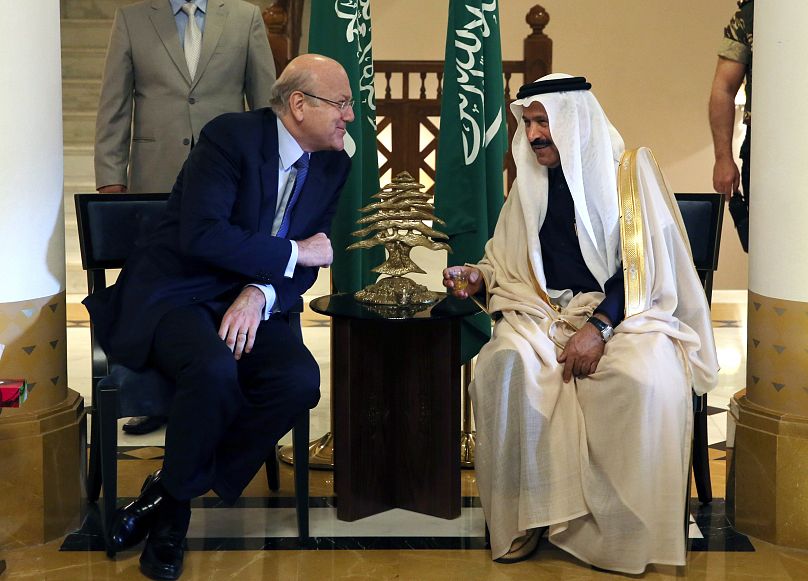 السفير السعودي في لبنان علي عواض عسيري، إلى اليمين، يتحدث مع رئيس حكومة تصريف الأعمال نجيب ميقاتي في السفارة السعودية في بيروت، لبنان، 24 فبراير/شباط 2016