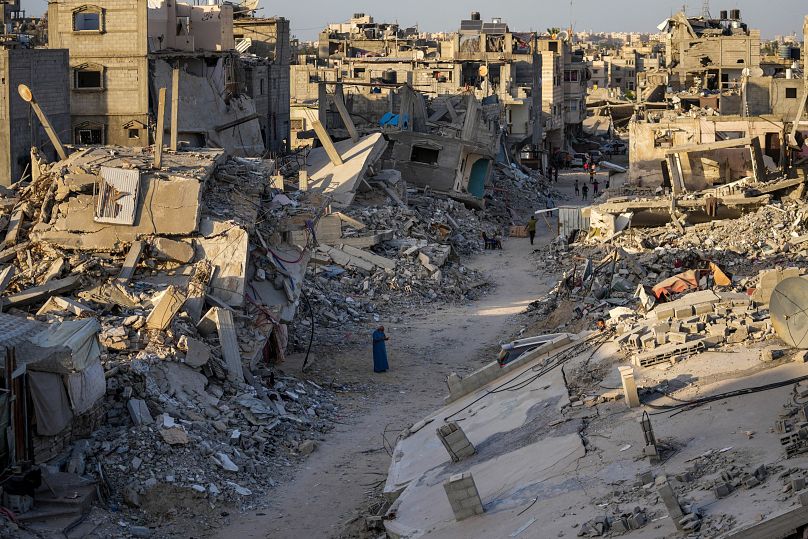 فلسطينيون يسيرون في الدمار الذي خلفه الهجوم الجوي والبري الإسرائيلي على خان يونس، قطاع غزة، الخميس، 12 سبتمبر/أيلول 2024