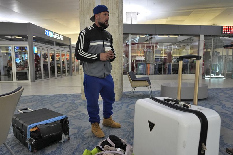 A passenger waits for transportation help to get to a shelter after his flight was canceled on Tuesday at the Tampa International Airport