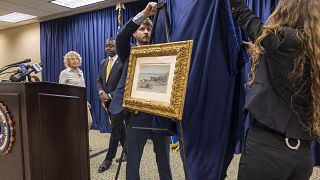 FBI agents unveil a Claude Monet painting to its original owners' descendants at the New Orleans office on Wednesday, 9 October 2024.