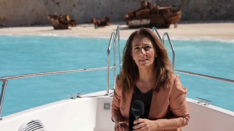 A jornalista Symela Touchtidou junto à carcaça do navio que naufragou na praia de Navagio. A praia está agora interditada.