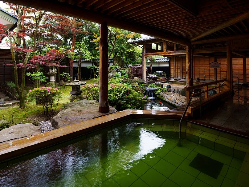 Baño al aire libre en Tsukioka Onsen Masyuu por la noche, con su agua de manantial natural de color verde esmeralda