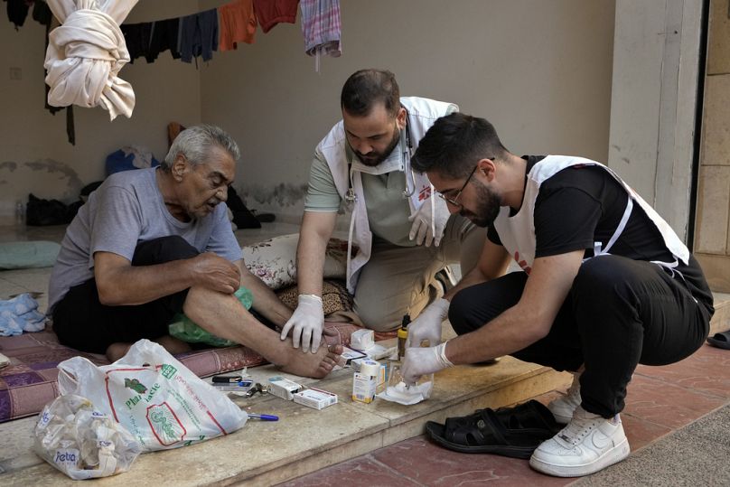 أعضاء من منظمة أطباء بلا حدود يعالجون نازحًا هاربًا من الغارات الجوية الإسرائيلية في الضاحية، في مجمع مبانٍ فارغ في بيروت، لبنان، الأربعاء، 9 أكتوبر/تشرين الأول 2024. 
