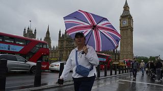 A woman walks past the Houses of Parliament in London
