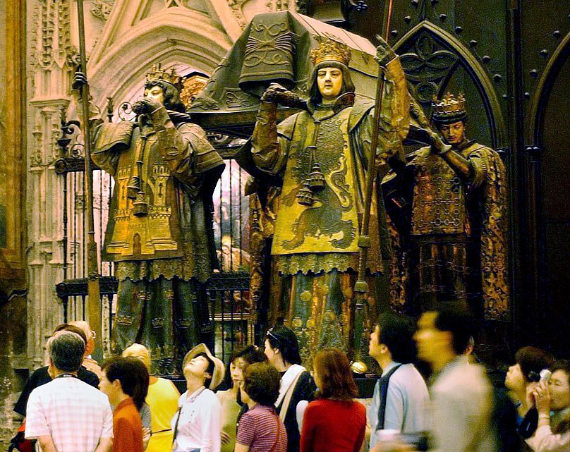 Tourists look at the tomb of Christopher Columbus in Seville Cathedral, Spain