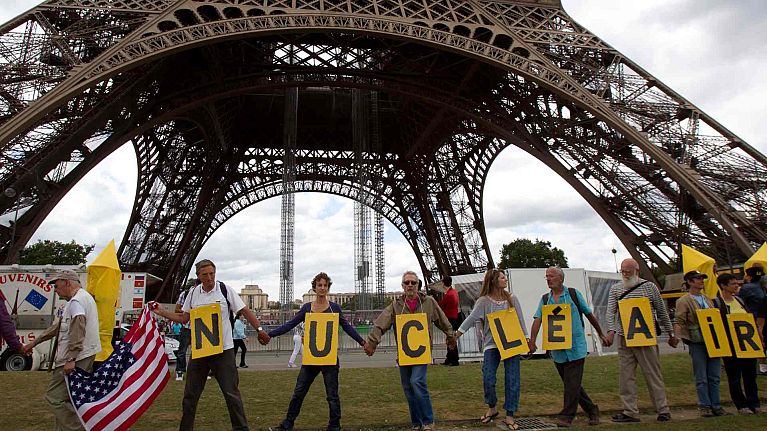 Anti nuclear activists form a human chain as they walk next to the Eiffel Tower, to mark 67th anniversary of the world's first atomic bomb attack in Hiroshima, Aug. 7, 2012