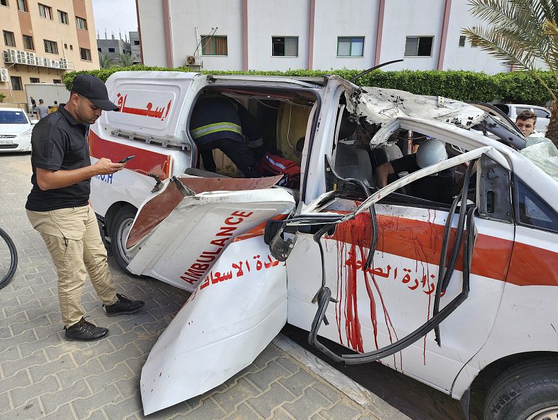 مسعفون فلسطينيون يتفقدون سيارة إسعاف متضررة أصيبت في غارة جوية إسرائيلية داخل مستشفى ناصر في خان يونس، جنوب قطاع غزة، السبت، 7 أكتوبر/تشرين الأول 2023