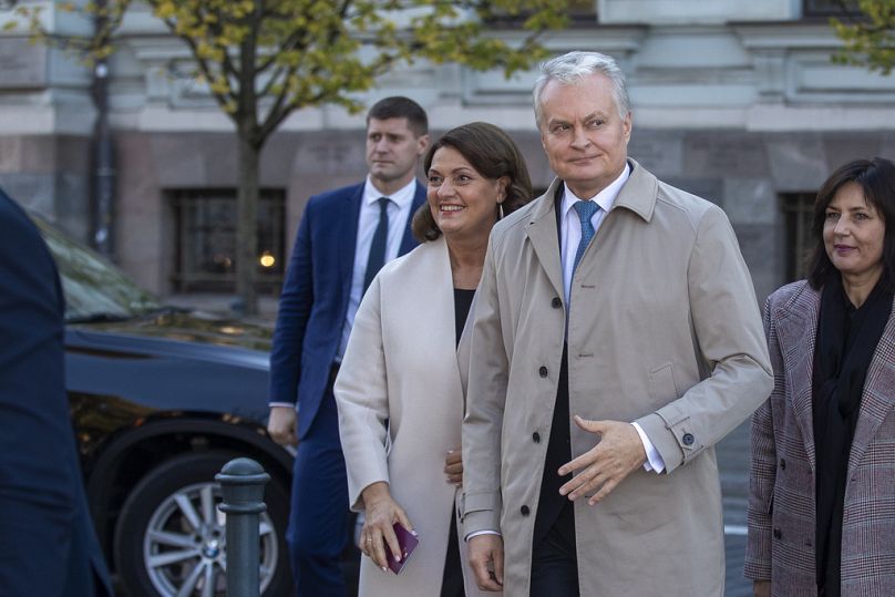 Le président lituanien Gitanas Nauseda et son épouse arrivent dans un bureau de vote à Vilnius le 8 octobre 2024