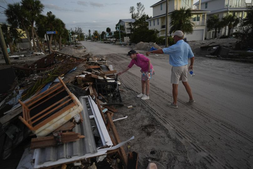 Karen and Burton Webb, whose property was washed through by Hurricane Milton surge, find pieces of their furniture a block from their house, in Englewood, Florida on Sunday