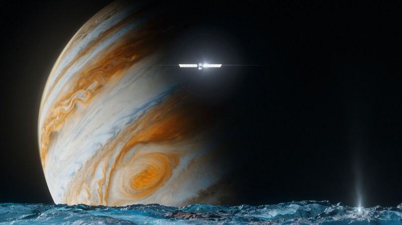 Αυτή η απεικόνιση που παρέχεται από τη NASA απεικονίζει το διαστημικό σκάφος Europa Clipper πάνω από την επιφάνεια του φεγγαριού Ευρώπη, σε πρώτο πλάνο, και τον Δία πίσω.