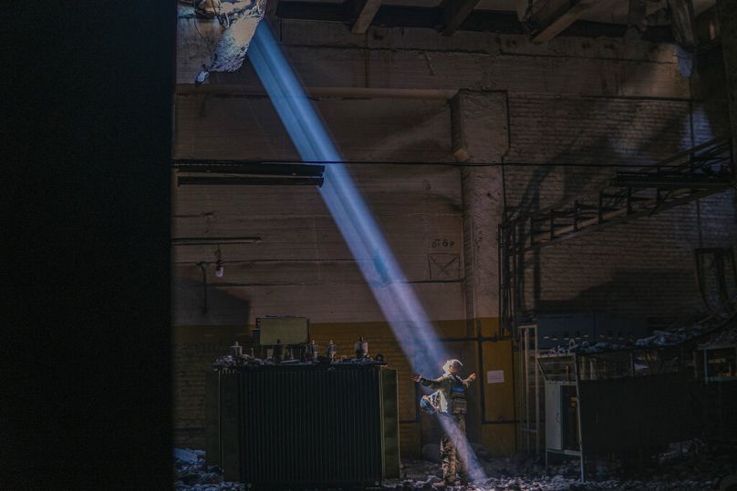 Un soldado ucraniano se encuentra en el interior de la planta siderúrgica en ruinas de Azovstal bajo un rayo de sol en su refugio en Mariúpol, el 7 de mayo de 2022.