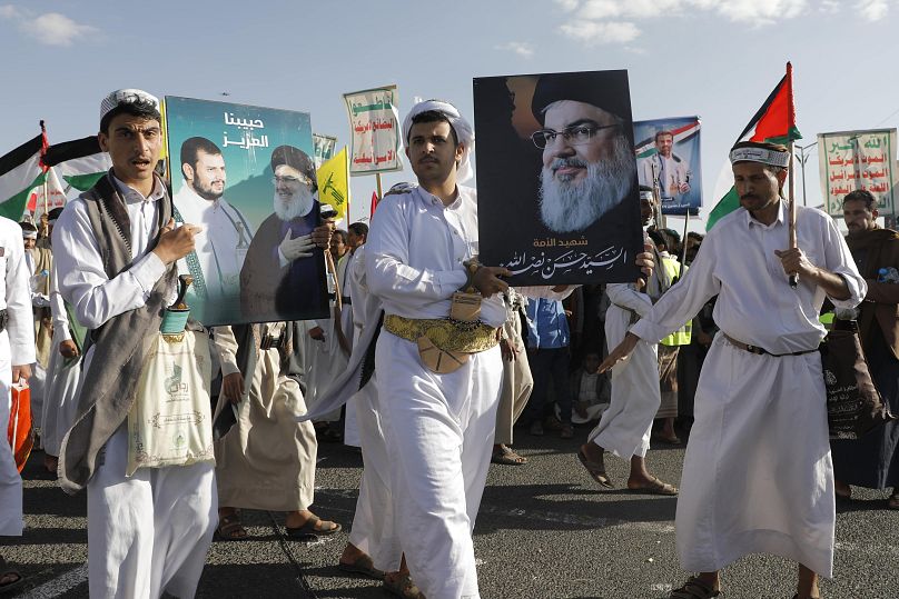 Des Houthis brandissent une affiche du défunt chef du Hezbollah Hassan Nasrallah lors du premier anniversaire de la guerre à Gaza, à Sanaa, au Yémen, le lundi 7 octobre 2024.