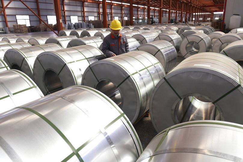 A worker checks on rolls of aluminium at a factory in Zouping county in east China's Shandong province, April 2018
