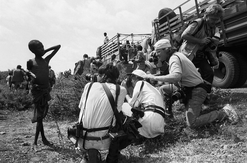 Western photojournalists take pictures of a starving child during the 1992 famine caused by the civil war in Somalia.
